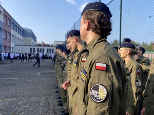 na zdjęciu uczniowie klasy mundurowej w szyku na uroczystości rozpoczęcia roku szkolnego na placu szkolnym