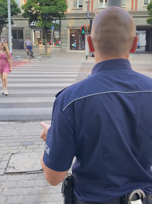 na zdjęciu policjant obserwujący przejście dla pieszych