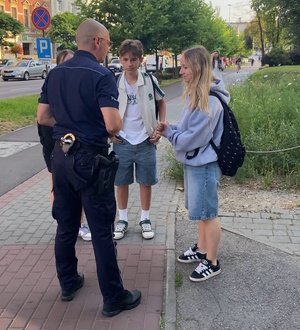 na zdjęciu policjant rozmawiający z uczniami w drodze do szkoły