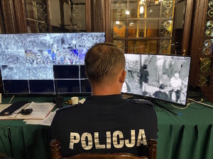 na zdjęciu policjant przy monitorach