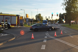 na zdjęciu samochodów osobowy z rozbitym przodem, a przed nim leżący uszkodzony motocykl, za nimi radiowóz, obok wóz strażacki