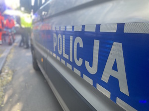 na zdjęciu fragment radiowozu z napisem policja