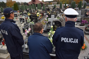 na zdjęciu policjanci i kapelan przed grobem