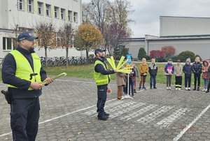 na zdjęciu dzielnicowi na placu szkolnym, w trakcie prelekcji z uczniami