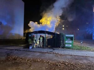 na zdjęciu strażacy przy wiacie śmietnikowej objętej pożarem