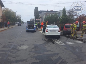 Na zdjęciu rozbite samochody osobowe na skrzyżowaniu obok radiowóz policjanci ratownicy medyczni strażacy