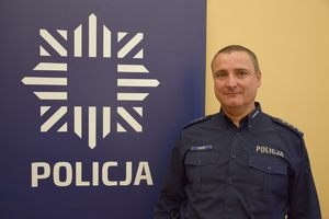 na zdjęciu dzielnicowy Frączek przy banerze z napisem policja