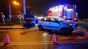 na zdjęciu dwa rozbite pojazdy, obok strażacy inne osoby i wóz strażacki