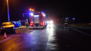 na zdjęciu dwa rozbite pojazdy, obok strażacy inne osoby i wóz strażacki