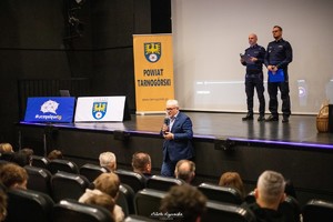 na zdjęciu burmistrz miasta w trakcie przemowy pod sceną, na scenie policjanci