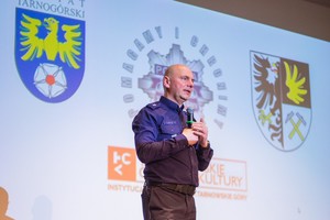 na zdjęciu policjant na scenie z mikrofonem