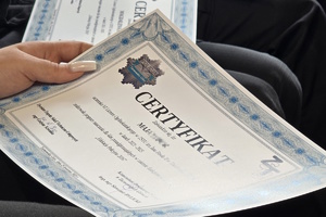 na zdjęciu dłoń osoby trzymająca w ręku certyfikat