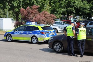 na zdjęciu policjanta przy samochodzie w trakcie kontroli