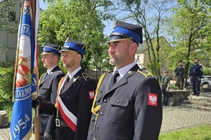 na zdjęciu poczet sztandarowy straży pożarnej przed dzwonnicą