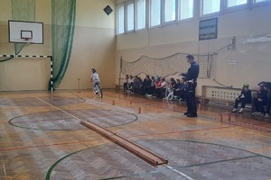 na zdjęciu policjant i rowerzyście na sali gimnastycznej
