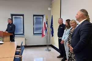 na zdjęciu policjant przy mównicy i przedstawiciele władz powiatu i miasta