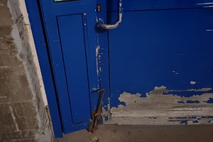 na zdjęciu drzwi z widocznymi uszkodzeniami