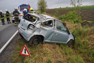 na zdjęciu rozbity pojazd w rowie, obok strażacy