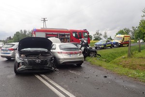 na zdjęciu rozbite pojazdy na jezdni, obok radiowozy policyjne, karetka i wóz strażacki
