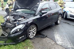 na zdjęciu uszkodzony pojazd na jezdni, obok fragment radiowozu