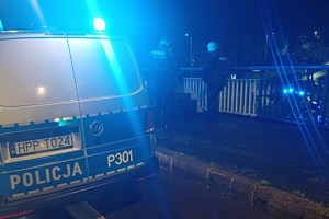 na zdjęciu policjanci na wiadukcie przy radiowozie i siedzącym na ziemi mężczyźnie