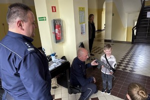 na zdjęciu policjanci prezentują dziecku swój sprzęt