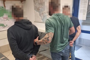 na zdjęciu policjant z zatrzymanymi