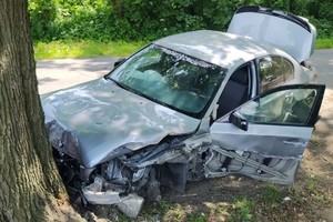 na zdjęciu uszkodzony samochód przy przydrożnym drzewie