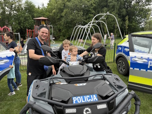 na zdjęciu osoby i policjantka przy policyjnym quadzie