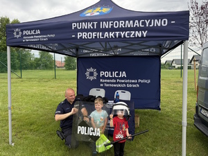 na zdjęciu dzieci z policjantem pod namiotem