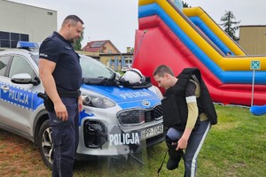 na zdjęciu policjant dziecko i radiowóz