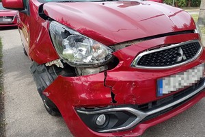 na zdjęciu czerwony samochód z uszkodzonym przodem