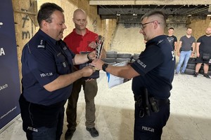 na zdjęciu komendant powiatowy wręcza nagrodę policjantowi