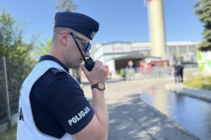 na zdjęciu policjant z radiotelefonem w ręku