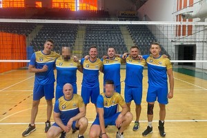 zdjęciu drużyny tarnogórskich policjantów w strojach sportowych na boisku do siatkówki