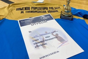 na zdjęciu koszulka, na której dyplom i fragment pucharu