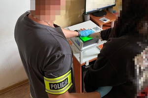 na zdjęciu technik kryminalistyki pobiera odciski palców od kobiety