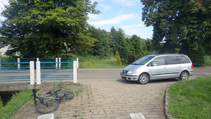 na zdjęciu samochód i leżący przed nim rower