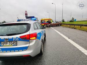 na zdjęciu radiowóz a przed nim karetka i samochód z uszkodzeniami