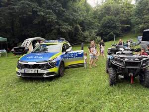 na zdjęciu radiowóz i quad na trawie w parku