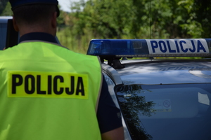 na zdjęciu policjant i neon na dachu radiowozu
