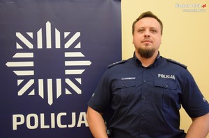 na zdjęciu dzielnicowy Kluba przy banerze z napisem policja