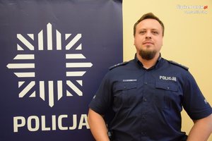 na zdjęciu dzielnicowy Kluba przy banerze z napisem policja