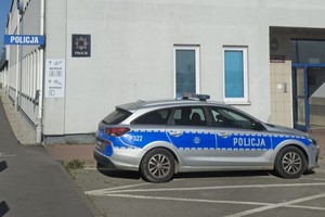 na zdjęciu radiowóz zaparkowany przed budynkiem komisariatu