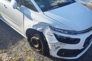 na zdjęciu biały samochód osobowy z uszkodzeniami