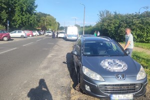 na zdjęciu pojazdy biorące udział w zdarzeniu, obok nich osoby i radiowóz oraz policjanci