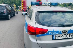 na zdjęciu radiowóz, wóz strażacki i czarny samochód osobowy na jezdni