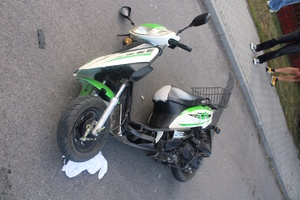 na zdjęciu leżący na jezdni motorower z uszkodzeniami