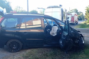 na zdjęciu samochód z uszkodzeniami, za nim radiowóz i wóz strażacki