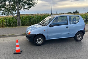 na zdjęciu samochód na jezdni i pachołek obok niego